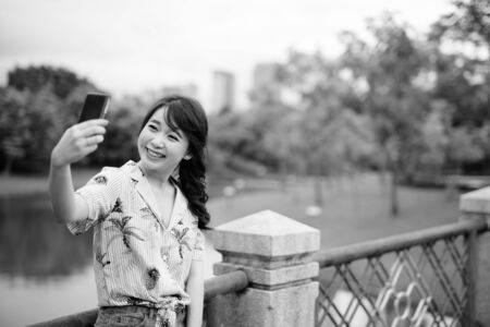 Young beautiful Asian tourist woman relaxing at the parkの写真素材