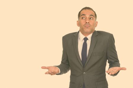 Portrait of confused mature Persian businessman shrugging shouldersの写真素材