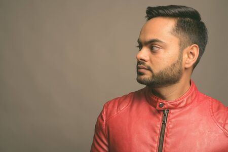 Young bearded Indian man against gray backgroundの写真素材