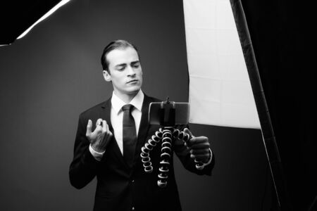 Young businessman against gray background in black and whiteの写真素材
