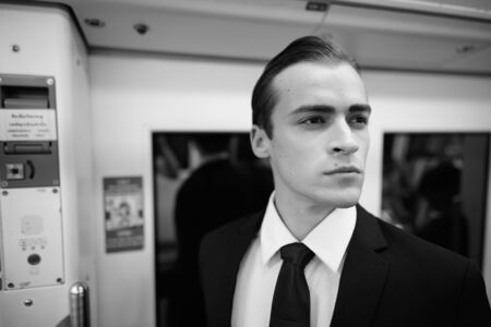 Young handsome businessman in suit exploring the city