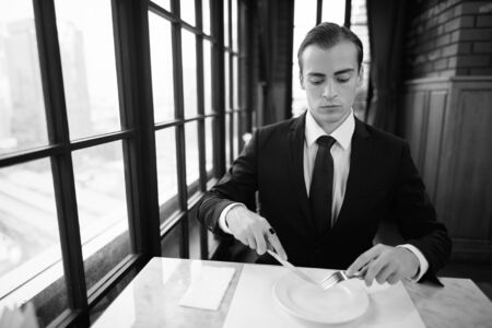 Young handsome businessman in suit exploring the city