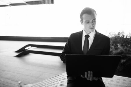 Young handsome businessman exploring the city streets at nightの写真素材