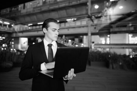 Young handsome businessman exploring the city streets at night
