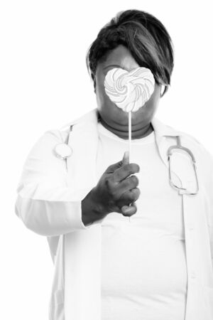 Studio shot of beautiful overweight African woman isolated against white background in black and whiteの写真素材