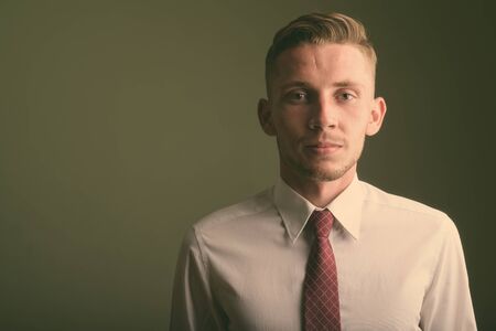 Portrait of young businessman against colored backgroundの写真素材
