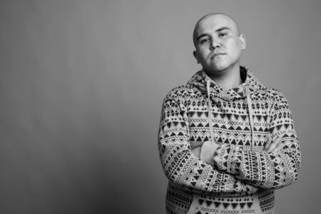 Portrait of young bald Asian man wearing hoodieの写真素材