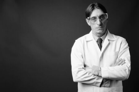 Mature handsome Italian man doctor wearing protective glassesの写真素材