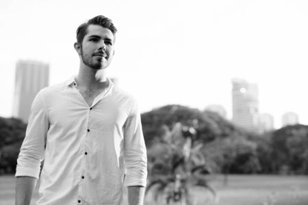 Portrait of young handsome man relaxing at the parkの写真素材