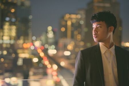 Young Asian businessman against view of the cityの写真素材