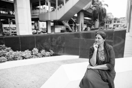 Portrait of mature beautiful Indian woman exploring the cityの写真素材