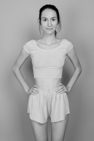 Young beautiful woman ready for gym against gray backgroundの写真素材