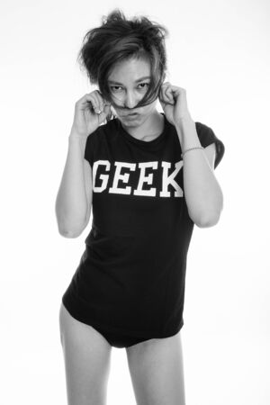 Studio shot of young Asian geek girl against white backgroundの写真素材