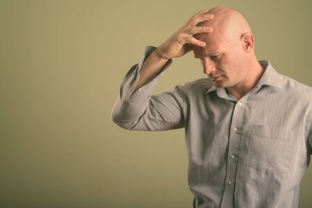 Portrait of bald businessman against colored backgroundの写真素材