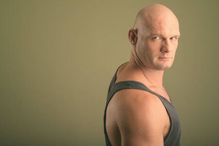 Bald muscular man wearing tank top against colored backgroundの写真素材