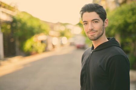 Young handsome man wearing hoodie in the streets outdoorsの写真素材