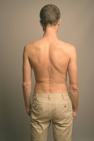 Portrait of handsome man shirtless against gray backgroundの写真素材