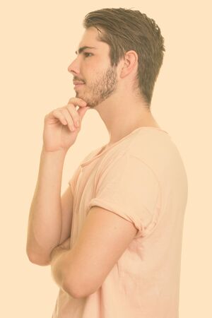 Profile view of young handsome Caucasian man thinkingの写真素材