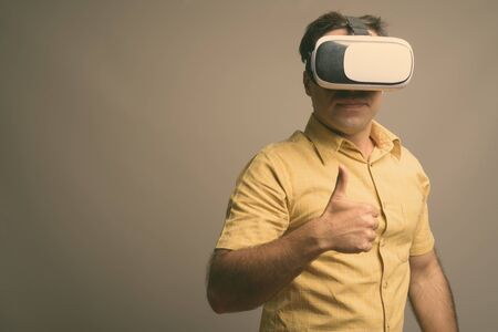 Portrait of handsome Persian man using virtual reality headset
