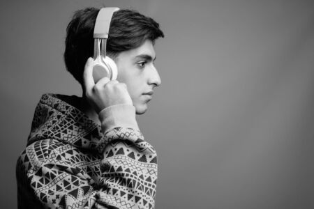 Young handsome Persian teenage boy against gray backgroundの写真素材