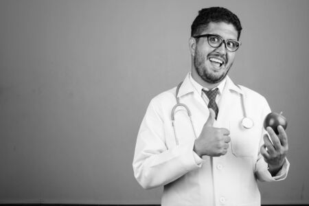 Bearded Persian man doctor against gray