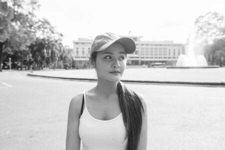 Young beautiful Asian tourist woman against view of historical building