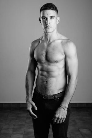 Young handsome man shirtless against white backgroundの写真素材