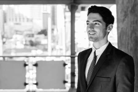 Portrait of young handsome businessman at the sky train station