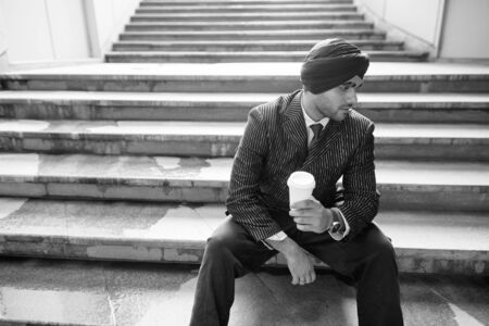 Young handsome Indian Sikh businessman by the staircaseの写真素材