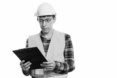 Portrait of man construction worker reading on clipboardの写真素材