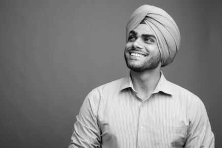 Young handsome Indian Sikh businessman wearing turban