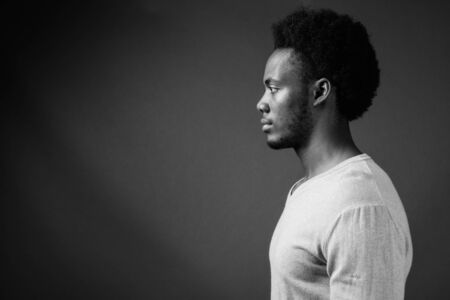 Young handsome African man against gray backgroundの写真素材