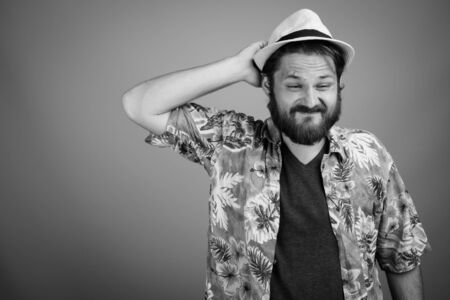 Young bearded tourist man ready for vacation against gray backgroundの写真素材