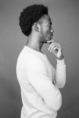 Young handsome African man against gray background