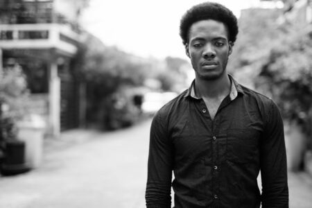Young handsome African businessman in the streets outdoorsの写真素材