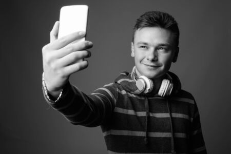 Portrait of young handsome man against gray backgroundの写真素材