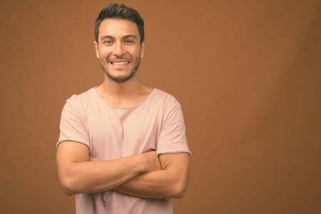 Young handsome Hispanic man against brown backgroundの写真素材