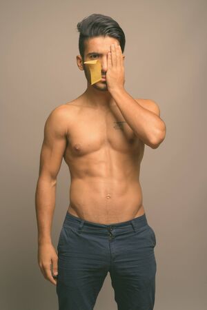 Young handsome Persian man shirtless against gray backgroundの写真素材