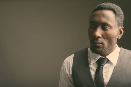 Young handsome African businessman against gray backgroundの写真素材