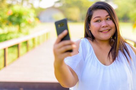 Beautiful overweight Asian woman relaxing at the park