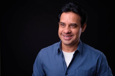 Mature handsome Indian man against black backgroundの写真素材