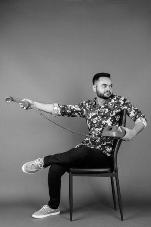 Young bearded Indian man against gray backgroundの写真素材