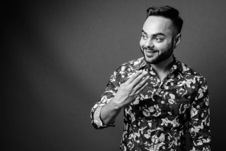 Young bearded Indian man against gray backgroundの写真素材
