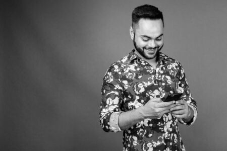Young bearded Indian man against gray backgroundの写真素材