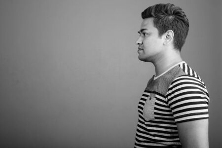 Indian man wearing striped shirt against gray backgroundの写真素材