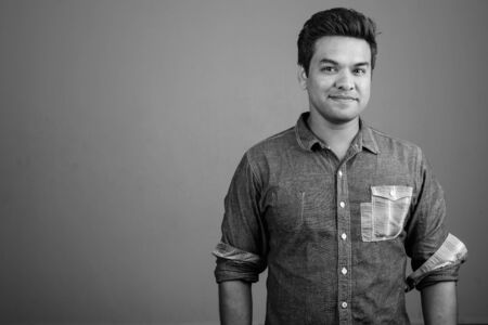 Indian man wearing denim shirt against gray backgroundの写真素材