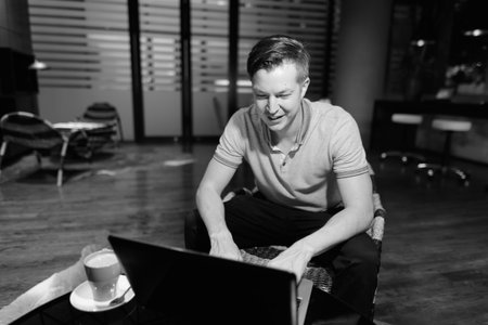 Young handsome man using laptop in the living room