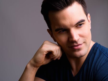 Face of young handsome man thinking and looking awayの写真素材