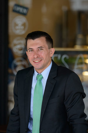 Happy young businessman smiling at the coffee shop outdoors