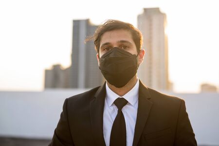 Young Persian businessman wearing mask for protection from corona virus outbreak and pollutionの写真素材